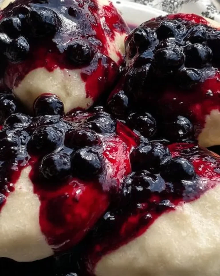 Dampfnudeln mit Heidelbeer-Soße auf einem Teller serviert