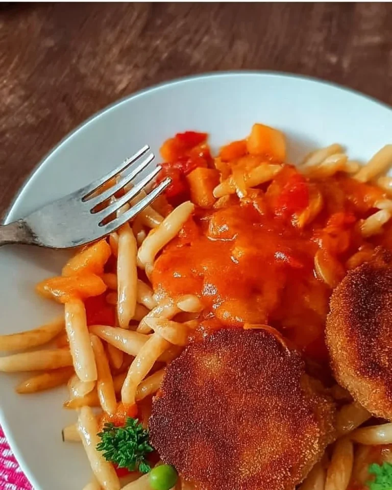 Nudeln mit Tomatensoße und Jägerschnitzel auf einem Teller angerichtet