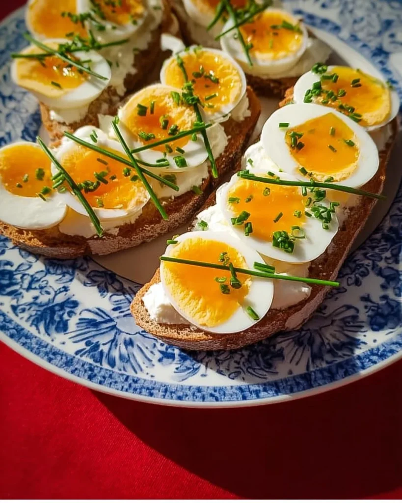 Ein schnelles Abendessen mit Brot mit Butter, hartgekochtem Ei und Schnittlauch.