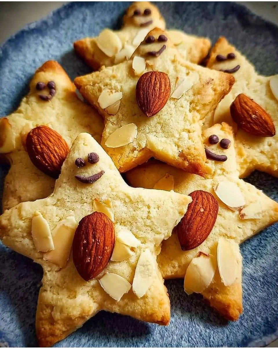 Leckere Sternenkekse mit Mandeln auf einem dekorativen Teller.