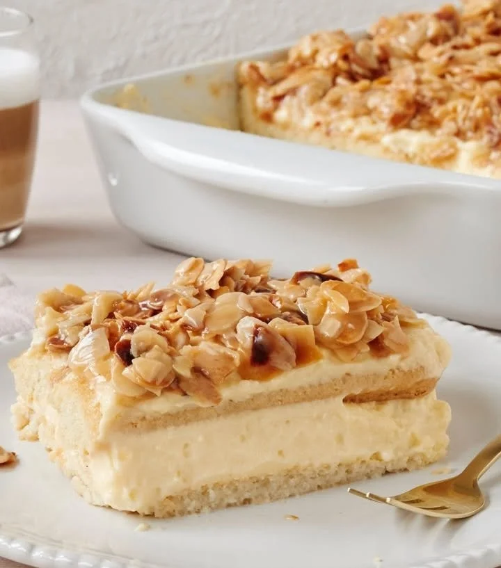 Bienenstich-Tiramisu mit Sahne und Mandeln auf einem Teller serviert.