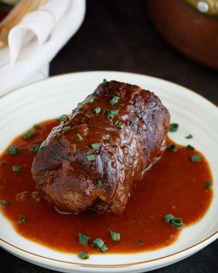 Klassische Rinderroulade zubereitet mit frischen Zutaten auf einem Teller.
