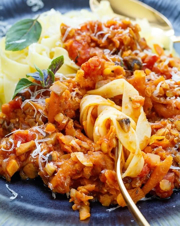 Linsenbolognese mit roten Linsen auf einem Teller serviert.