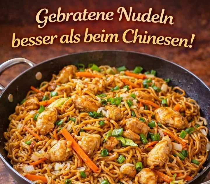 Gebratene Nudeln mit Hühnchen auf einem Teller serviert.