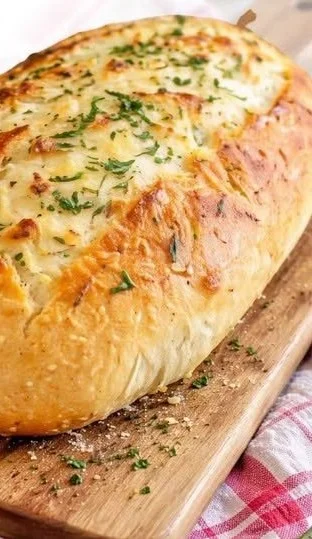 Leckeres Knoblauchbrot ohne Kneten auf einem Holzbrett serviert.