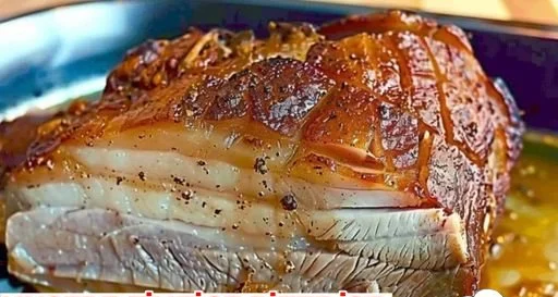 Leckerer Kümmelbraten auf einem Teller, serviert mit Beilagen.