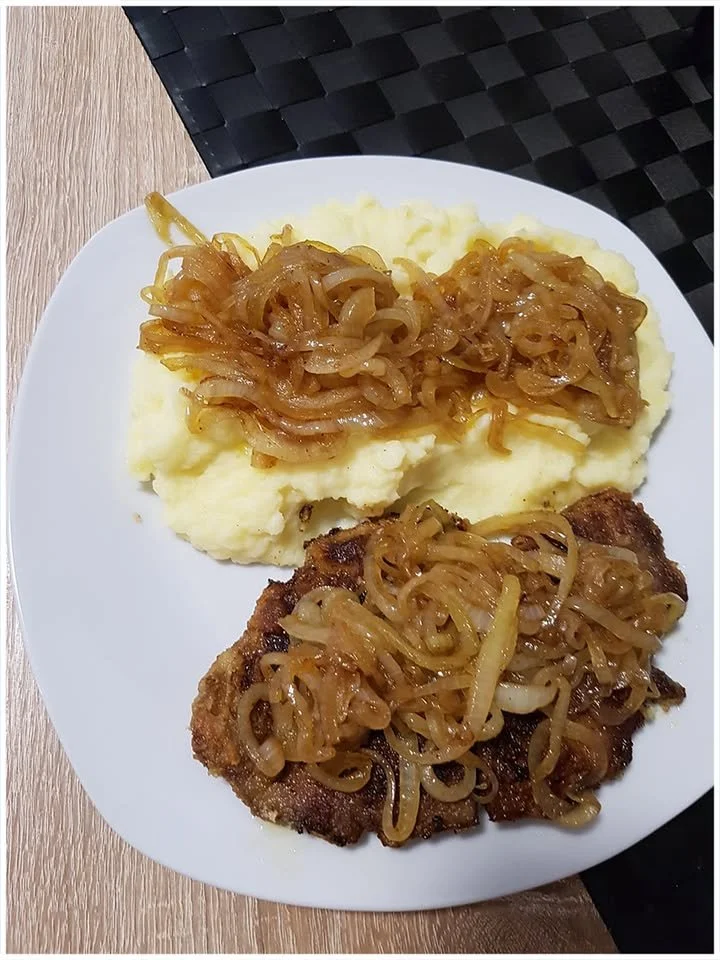 Leber mit Kartoffelpüree und gebratenen Zwiebeln auf einem Teller serviert