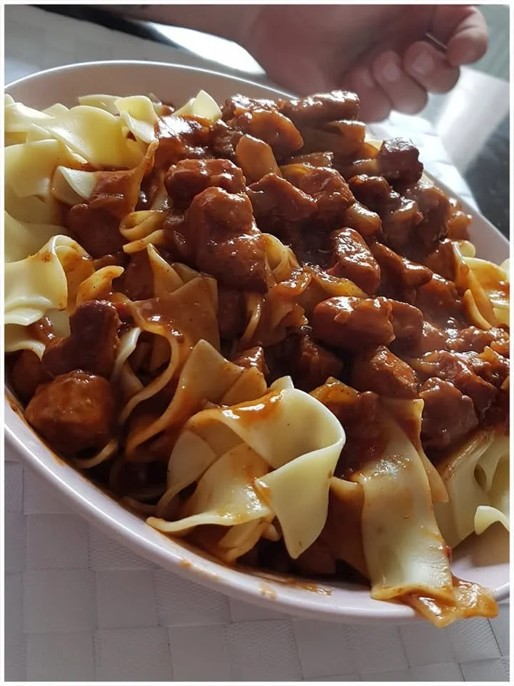 Leckere Bandnudeln mit Gulasch auf einem Teller serviert