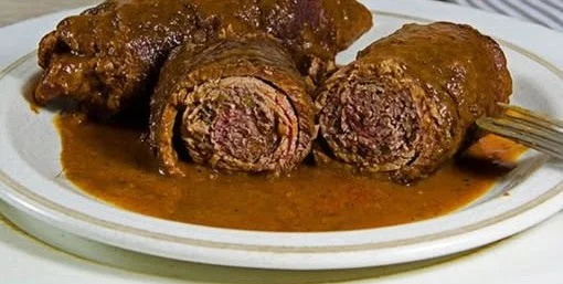 Leckere Rinderroulade auf einem Teller, serviert mit Beilagen