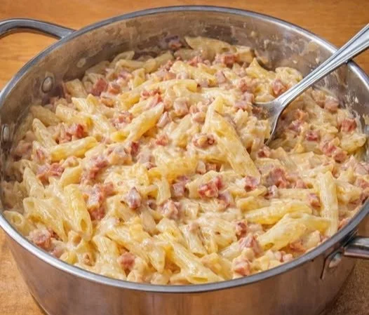 Schinken Nudeln mit Schmand auf einem Teller serviert.