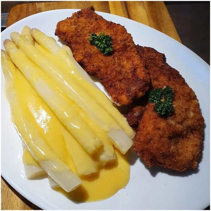 Spargel Schnitzel mit Sauce Hollandaise auf einem Teller serviert
