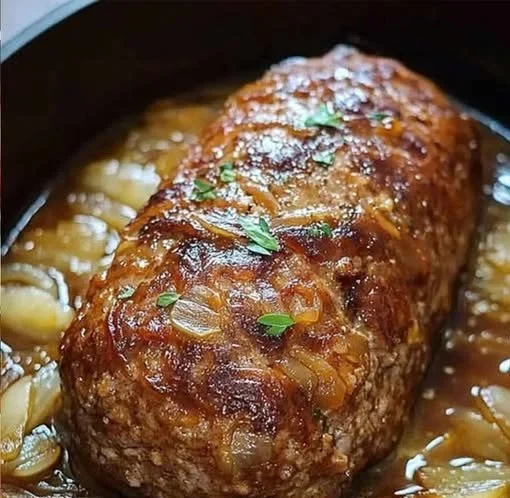 Supersaftiger Zwiebel-Hackbraten auf einem Holzbrett serviert.